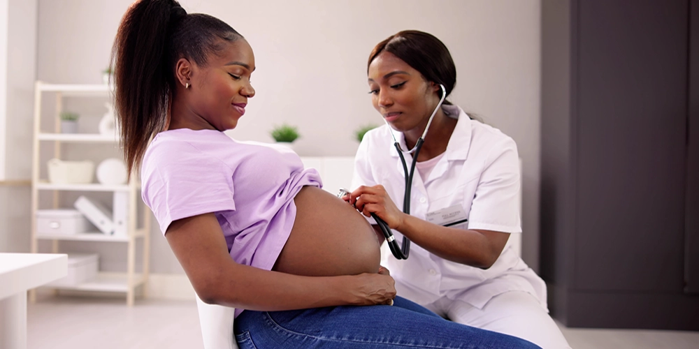 Black Physician treating pregnant woman
